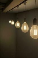 une groupe de lumière ampoules pendaison de une plafond. ai généré photo