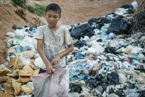 pauvres garçon collecte des ordures dans le sien sac à gagner le sien moyens de subsistance, le concept de pauvres les enfants et la pauvreté photo
