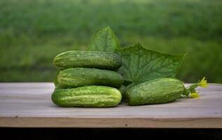 Frais biologique concombres sur une marron en bois tableau. salade ingrédient, Frais légumes, végétalien nourriture photo