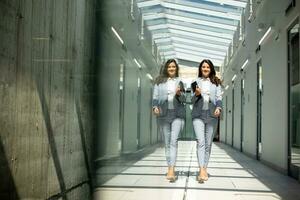 Jeune femme en marchant avec numérique tablette dans le Bureau couloir photo