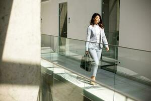 Jeune affaires femme en marchant avec mallette dans le Bureau couloir photo