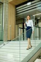 jeune affaires femme en marchant sur escaliers dans le Bureau couloir photo