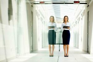 Jeune femme travail sur numérique tablette dans le Bureau couloir photo