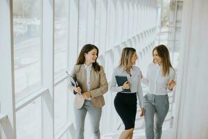 Trois Jeune affaires femmes en marchant sur escaliers dans le Bureau couloir photo
