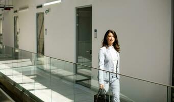 Jeune affaires femme en marchant avec mallette dans le Bureau couloir photo