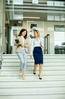 deux Jeune affaires femmes en marchant sur escaliers dans le Bureau couloir photo