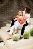 souriant Jeune couple dans l'amour dans de face de maison brique mur photo