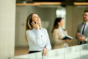 Jeune affaires femme avec mobile téléphone dans le Bureau couloir photo