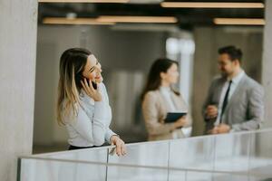 Jeune affaires femme avec mobile téléphone dans le Bureau couloir photo