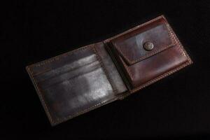 cuir ouvert portefeuille dans marron sur une noir Contexte. photo