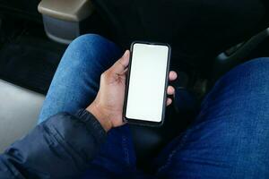 main tenant un téléphone intelligent avec écran vide dans une voiture photo