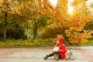 adorable peu écolière en train d'étudier en plein air sur brillant l'automne journée. Jeune étudiant Faire sa devoirs. éducation pour petit enfants. retour à école concept. photo