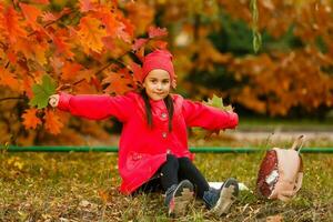 élève de primaire école avec livre dans main. fille avec sac à dos près bâtiment en plein air. début de cours. premier journée de automne. photo