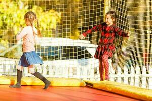 content école fille sauter sur trampoline dans le l'automne parc photo