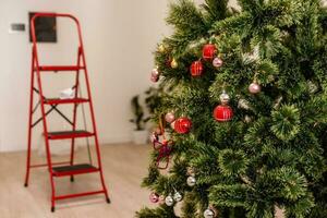échelle permanent à côté de une décoré Noël arbre photo