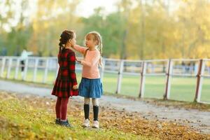 deux peu les filles dans l'automne parc photo