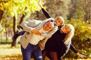 le famille des promenades dans le parc dans l'automne photo