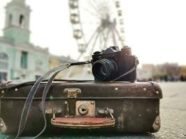 vieux caméra et valise contre le Contexte de le ferris roue photo