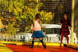 content école fille sauter sur trampoline dans le l'automne parc photo
