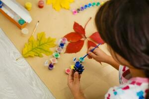 peu enfant fabrication l'automne décoration de châtaigne, pin cônes et glands photo