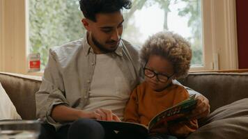 livre de lecture père avec fils sur canapé à la maison photo