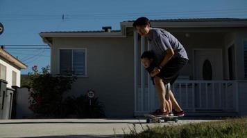 Portrait de père et fils patinant sur une planche à roulettes photo