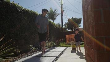 portrait de père et fils marchant avec skateboard photo