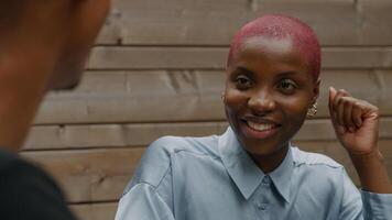 jeune femme aux cheveux roses rasés écoute collègue photo