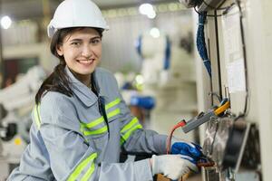 électricité ingénieur femelle travail vérifier un service haute Tension électrique armoire. ouvrier réparation électrique poussée problème problème dans industrie usine. photo