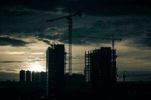 grue et bâtiment construction site à le coucher du soleil photo