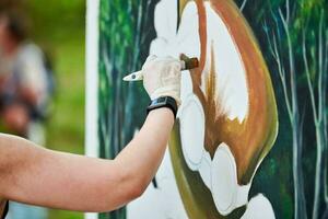 fille artiste main détient peindre brosse et dessine vert la nature paysage sur Toile photo