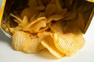 croustilles, délicieux assaisonnements pour barbecue épicés pour les crips, collations frites en fines tranches de restauration rapide dans un sac ouvert. photo