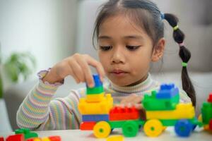 adorable petite fille jouant des blocs de jouets dans une pièce lumineuse photo