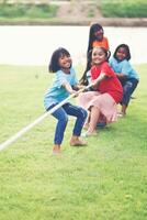 les enfants groupe en jouant remorqueur de guerre à le parc photo