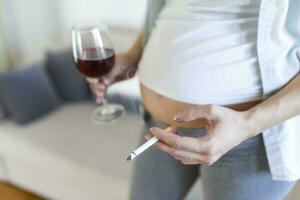 fumeur et de l'alcool grossesse.femme sur une longue grossesse en buvant de l'alcool et fumeur cigarettes.problèmes de alcoolisme et le période de palier une enfant.danger de perdant une bébé, fausse-couche. alcoolique photo