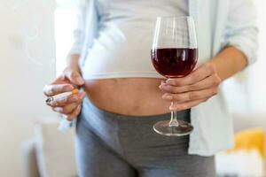 fumeur et de l'alcool grossesse.femme sur une longue grossesse en buvant de l'alcool et fumeur cigarettes.problèmes de alcoolisme et le période de palier une enfant.danger de perdant une bébé, fausse-couche. alcoolique photo