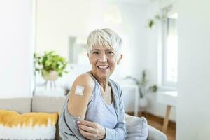adhésif bandage sur bras après injection vaccin ou médecine, adhésif des pansements plâtre - médical équipement, doux concentrer adhésif bandage sur une femelle brachium après covid-19 vaccination photo