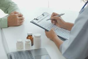 médecin donnant espoir. proche en haut coup de Jeune femelle médecin penché vers l'avant à souriant personnes âgées Dame patient en portant sa main dans palmiers. femme le concierge dans blanc manteau justificatif encourageant vieux la personne photo