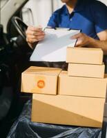 asiatique livraison homme dans cargaison van vérification des boites. photo