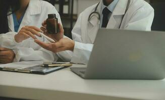 coup de une femelle médecin travail sur médical compétence tandis que séance à bureau dans de face de portable. photo