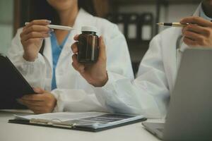 coup de une femelle médecin travail sur médical compétence tandis que séance à bureau dans de face de portable. photo