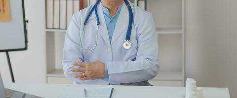 médecin donnant espoir. proche en haut coup de Jeune femelle médecin penché vers l'avant à souriant personnes âgées Dame patient en portant sa main dans palmiers. femme le concierge dans blanc manteau justificatif encourageant vieux la personne photo