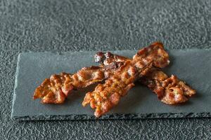 frit Bacon bandes sur le pierre foncé planche photo