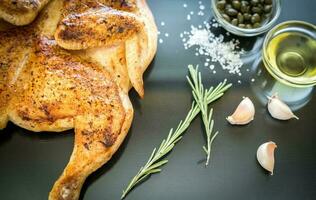 poulet grillé avec des ingrédients sur le fond en bois foncé photo