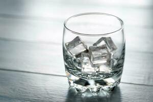 verre avec la glace cubes sur le en bois table photo