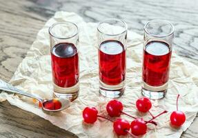 verres de cherry brandy avec des cerises à cocktail photo