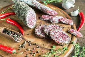 tranches de saucisson et fuet sur la planche de bois photo