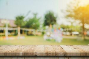 dessus de table en bois vide et bokeh léger flou abstrait et arrière-plan flou d'arbres de jardin au soleil. modèle d'affichage de produit avec espace de copie. photo