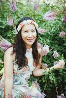 content métisse Japonais femme avec fleur cheveux bande dans jardin photo