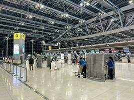 sur juillet dix, 2023, clairsemé les passagers et repos des employés peupler le enregistrement compteur de une Bangkok Compagnie aérienne, suvarnabhumi aéroport. photo